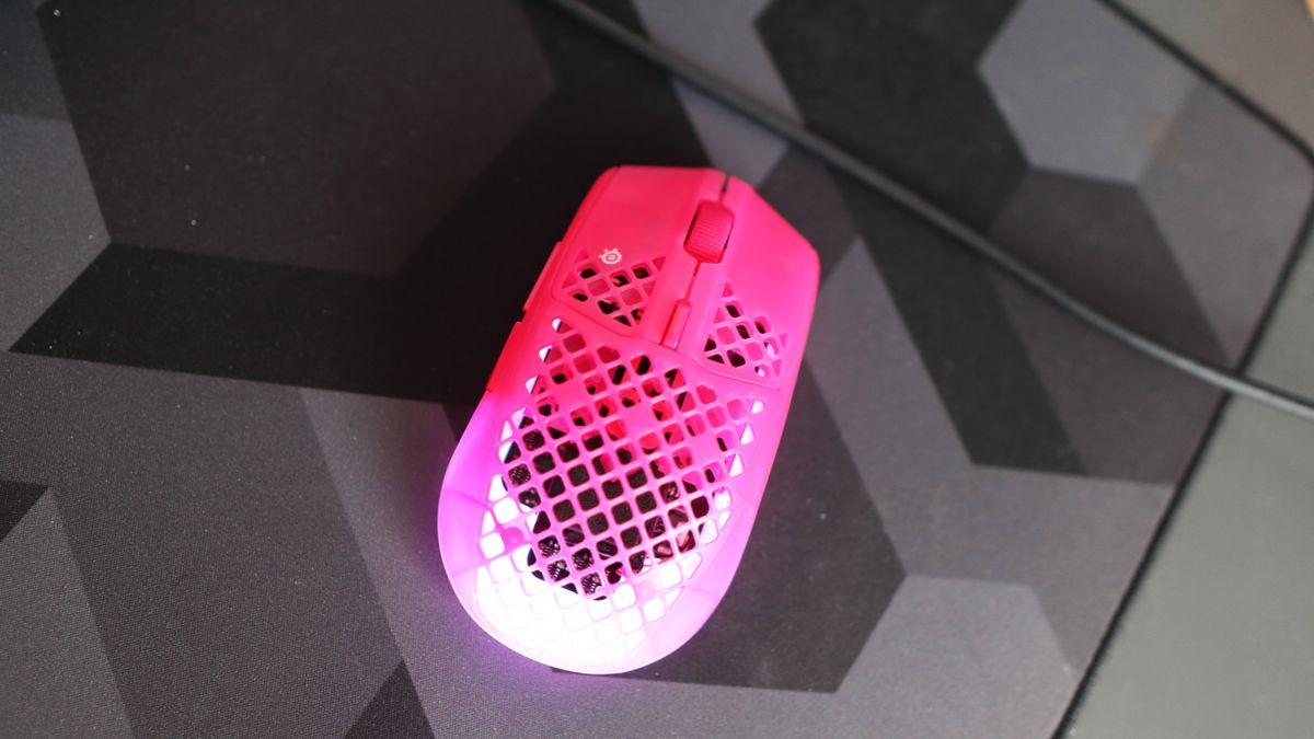 The SteelSeries Aerox 3 Wireless Gen 2 looking excellent in pink on a grey mousepad.