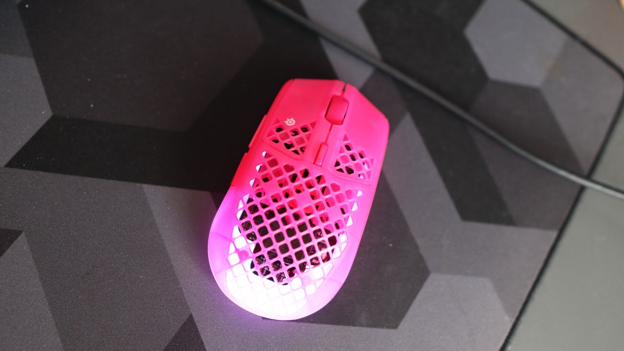 The SteelSeries Aerox 3 Wireless Gen 2 looking excellent in pink on a grey mousepad.