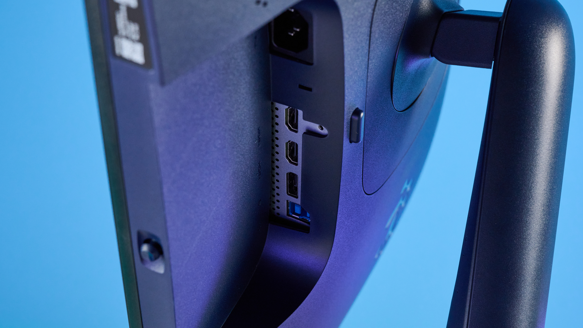 Alienware AW2725D on a desk against a blue background