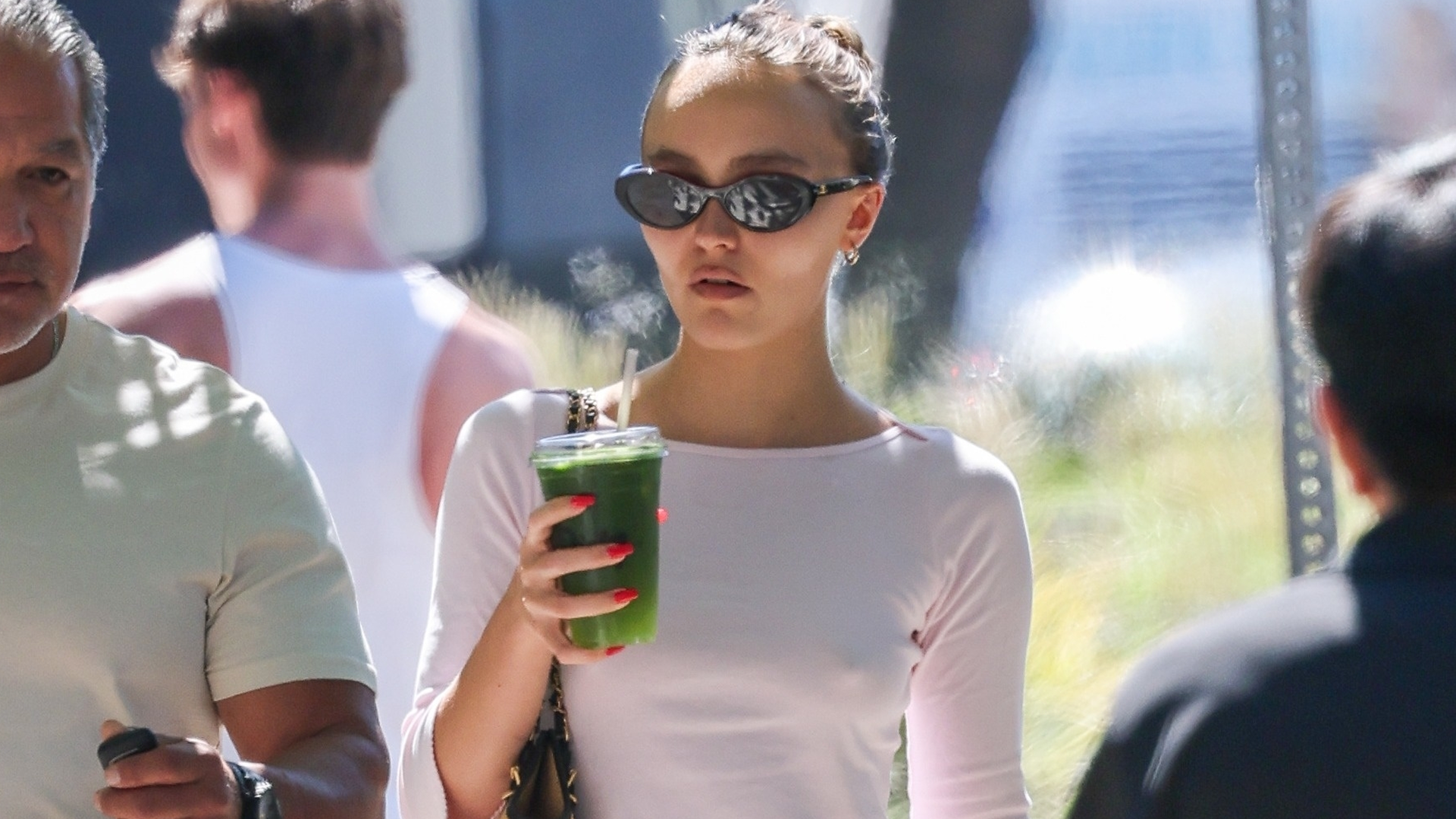 Lily-Rose Depp styled blue ballet flats with a white long-sleeve and black capri pants
