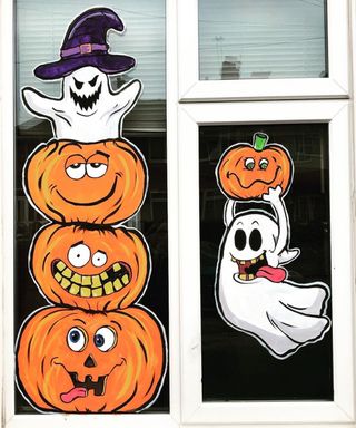 Halloween window decorating ideas with painted pumpkin and ghosts