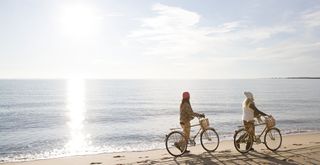 two women with bikes on beach