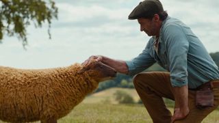 Hugh Jackman petting a sheep in new movie The Sheep Detectives