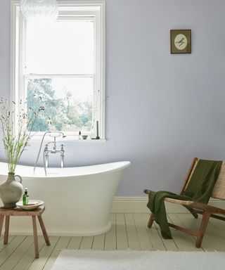 Elegant bathroom with pale lilac walls and freestanding white bath