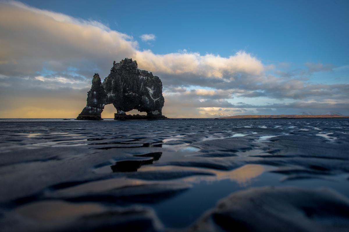 Icelandic scenery featuring an icy arch on frozen water