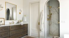 A neutral guest bathroom with a dark wood vanity and marble shower