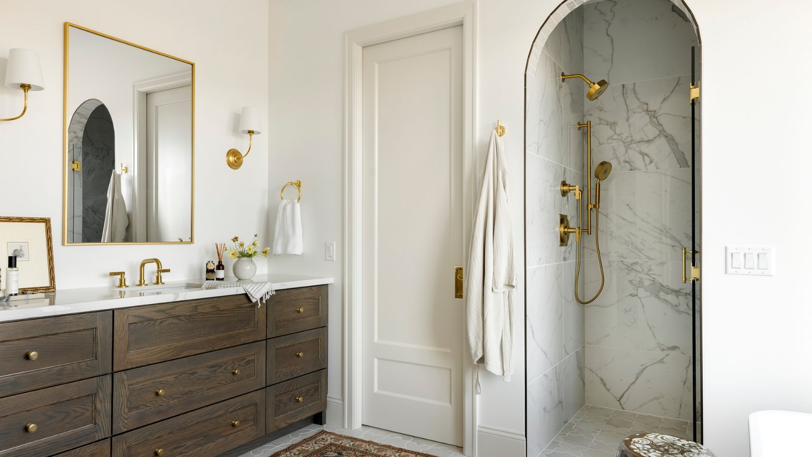 A neutral guest bathroom with a dark wood vanity and marble shower