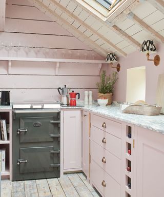 small pink rustic kitchen with a dark grey cooker