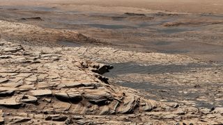 NASA's Curiosity Mars rover captured this view, which was stitched together from 28 different images, from "Greenheugh Pediment" on April 9, 2020. In the foreground is the pediment's sandstone cap. At center is the "clay-bearing unit," and the floor of Gale Crater is in the distance.