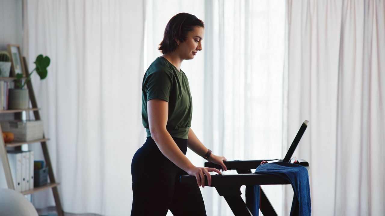 Woman walking on treadmill at home