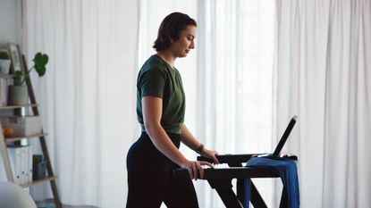 Woman walking on treadmill at home