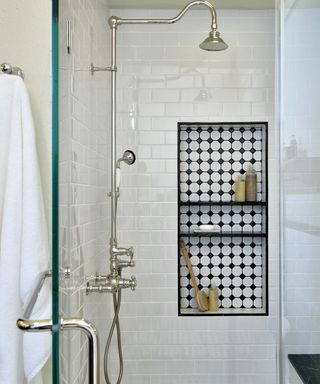 A shower enclosure with vintage monochrome tiling and matching shower floor tiles