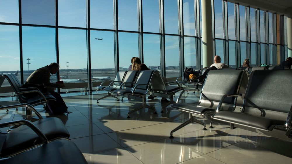 A business person sitting in a relatively empty airport waiting lounge