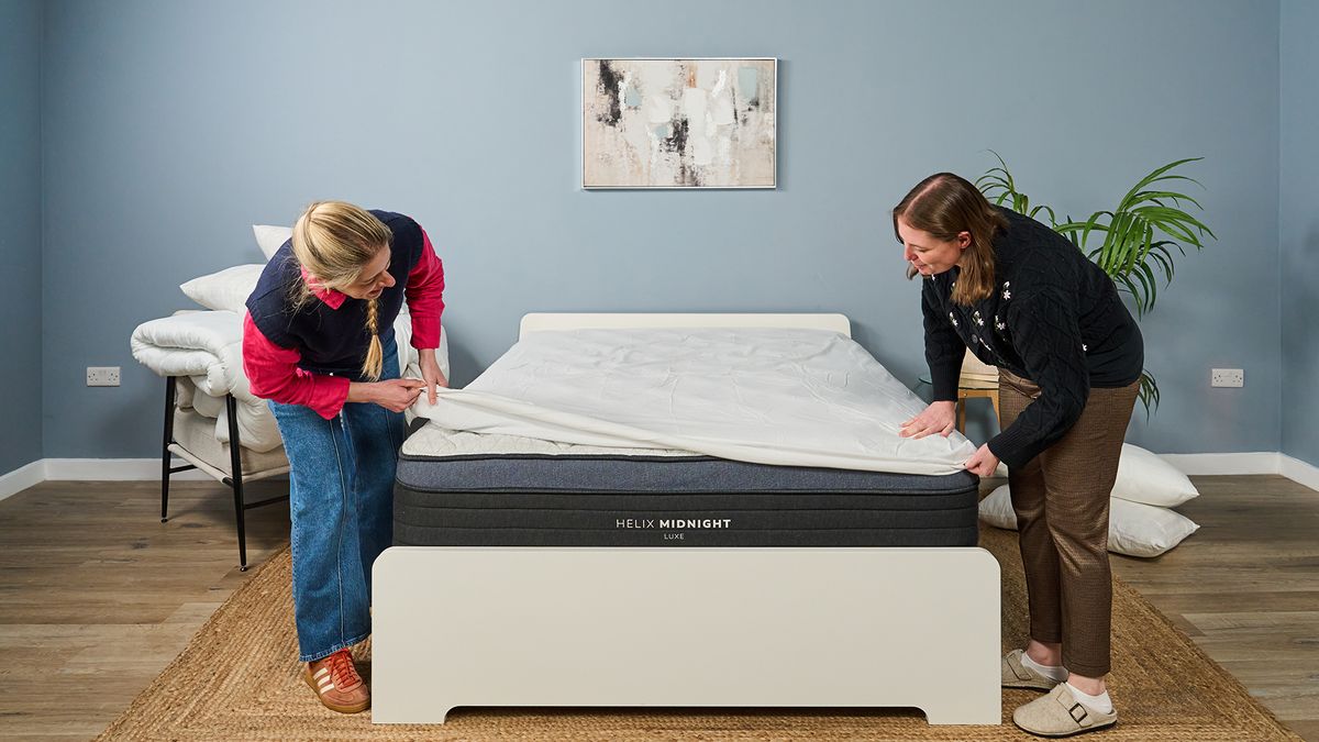 Two Tom's Guide mattress testers cover the Helix Midnight Luxe with a white mattress protector to keep it clean after testing