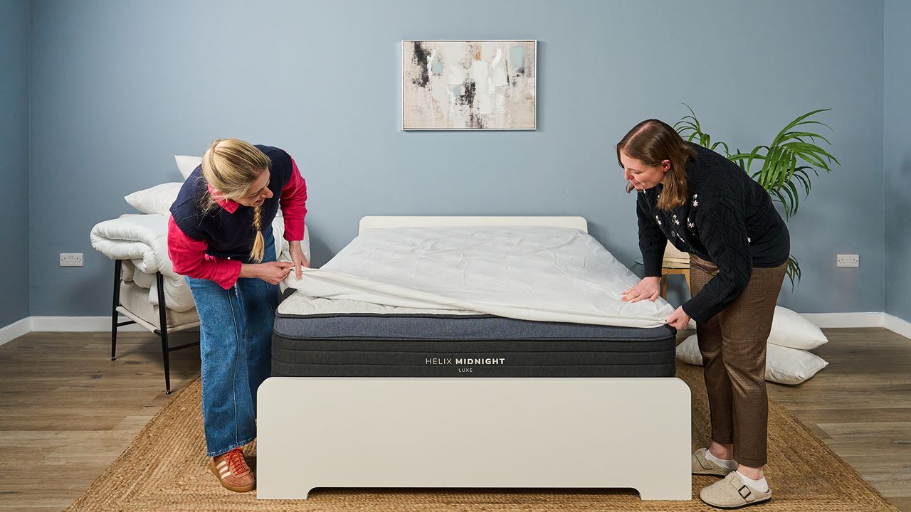 Two Tom's Guide mattress testers cover the Helix Midnight Luxe with a white mattress protector to keep it clean after testing