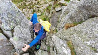 Rock climbing man wearing Sea to Summit Flow 35L Dry Pack