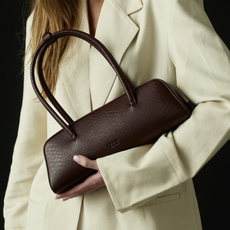 Woman wearing brown freja nyc vegan leather bag.