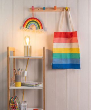 table light with yellow and white striped ceramic base and filament lightbulb on child's shelving unit