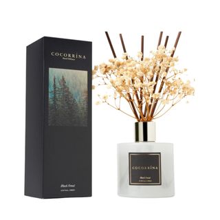 A black box next to a white reed diffuser with baby