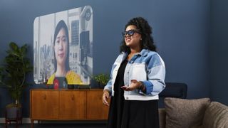 Press photo of a woman wearing the Meta Project Orion AR glasses and making a video call.