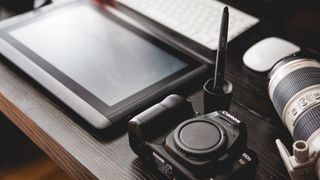 Wacom tablet on a desk next to a Canon camera