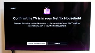 A TV with the message "Confirm this TV is in your Netflix Household" — a part of the Netflix password-sharing crackdown