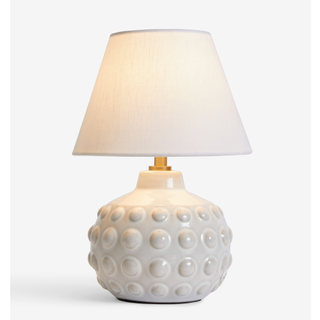 A small white ceramic table lamp with white shade