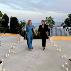 Sofia wears a black jacket and black maxi dress.