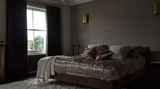 Neutral grey bedroom, fabric wallpaper, gold quilted silk bedspread
