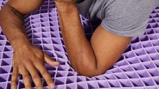 Is Purple mattress any good? Man's arms resting on polymer grid