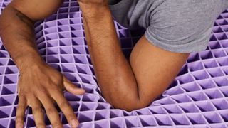 Is Purple mattress any good? Man's arms resting on polymer grid