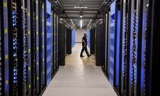 An employee walks past servers at the Facebook Data Center in Forest City, N.C.