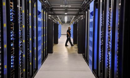An employee walks past servers at the Facebook Data Center in Forest City, N.C.