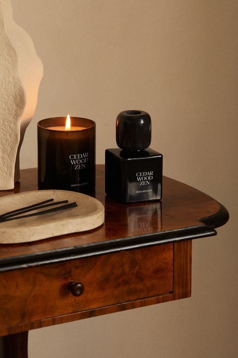 Reed Diffuser from H&amp;amp;M styled on a dark wooden table in a neutral room.