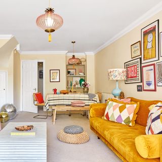 Living room with dining room area, a yellow sofa and gallery wall
