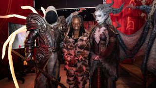 Whoopi Goldberg stands, flanked by Lilith and Inarius from Diablo 4.