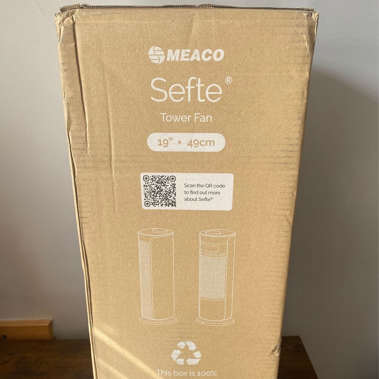 Outer packaging of the Meaco Sefte Tower Fan in front of a taupe wall