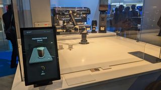 A mechanical arm making coffee at MWC 2023.