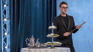 Christian Siriano holding a scepter in Project Runway All-Stars