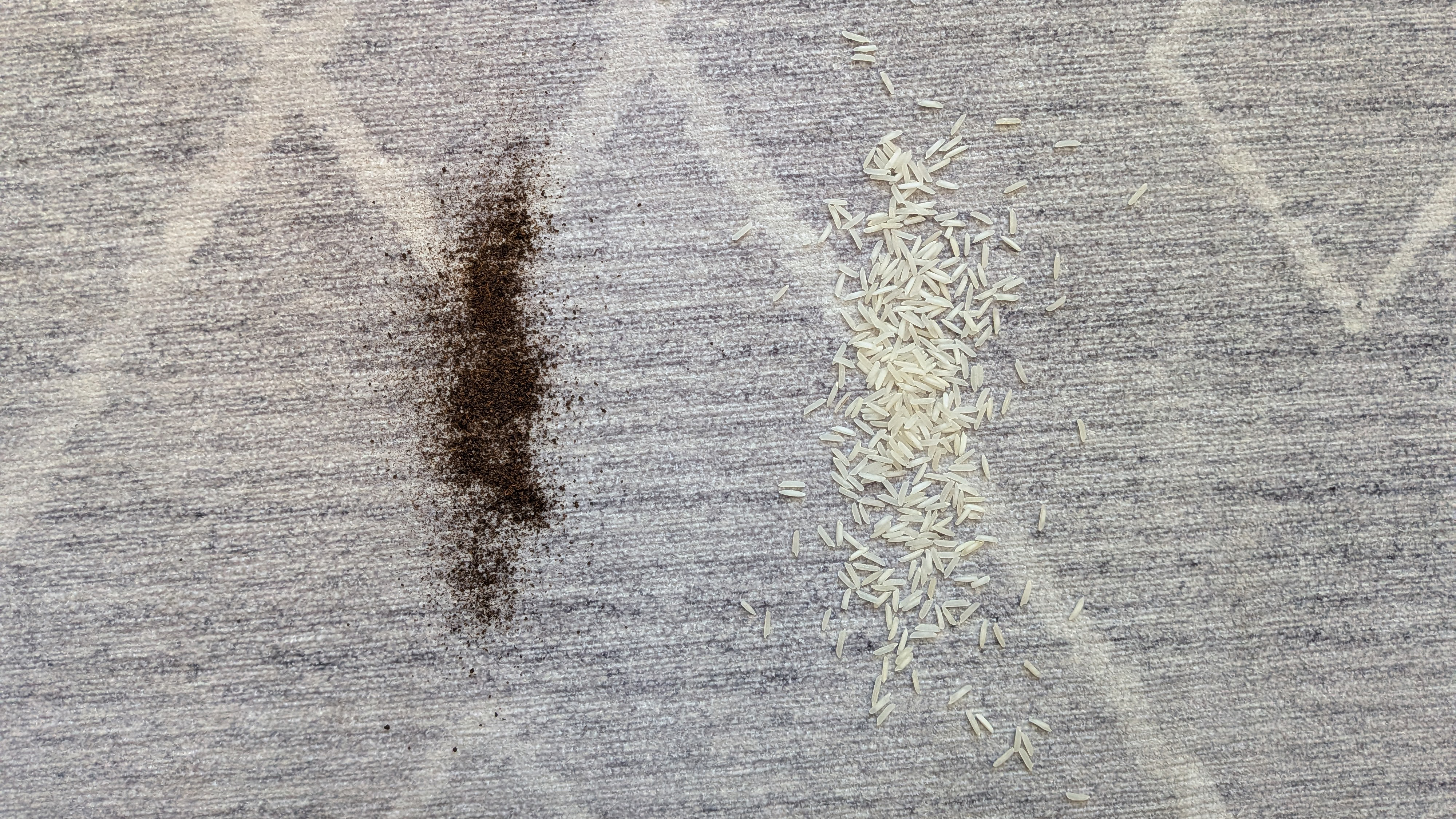 Pile of dry tea and rice on low-pile carpet before the vacuuming test