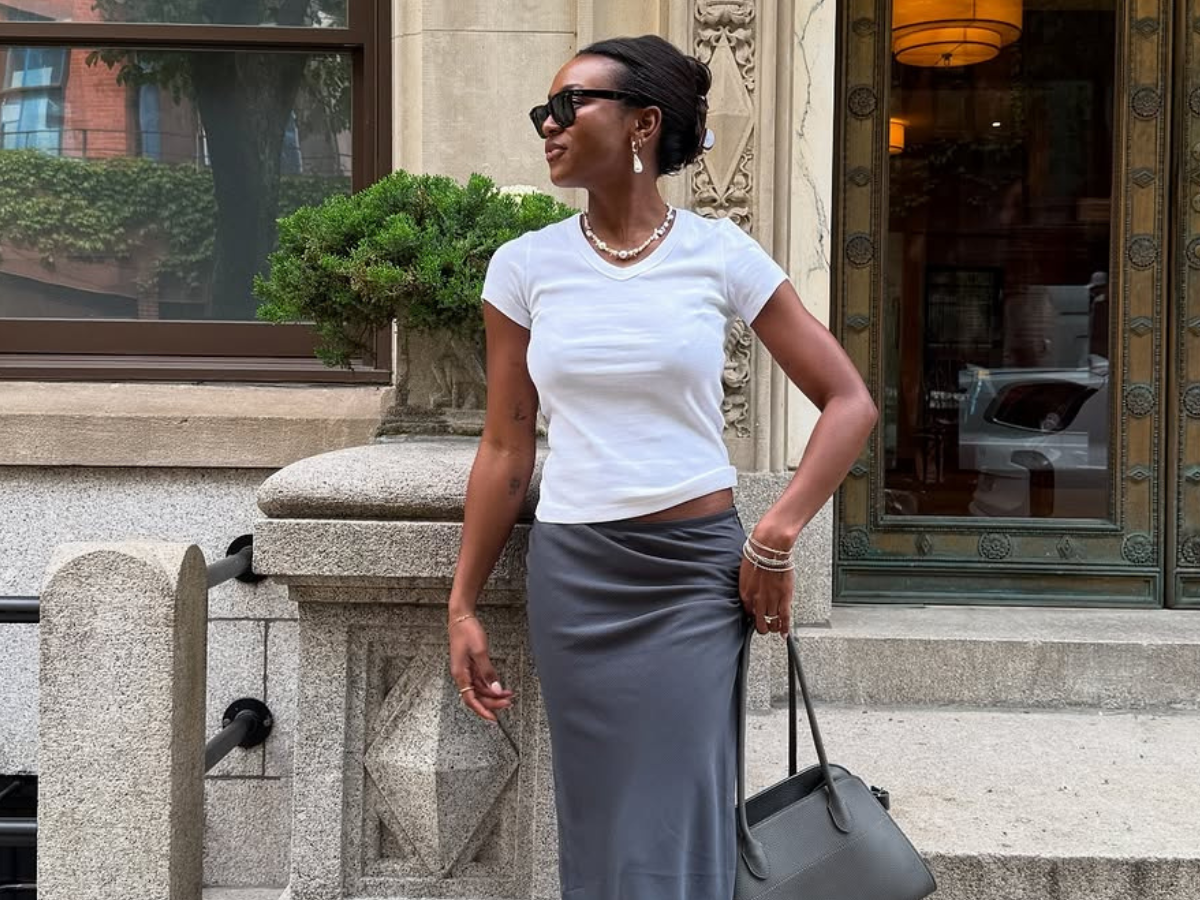 Woman wearing white t-shirt and long silk skirt summer 2025.