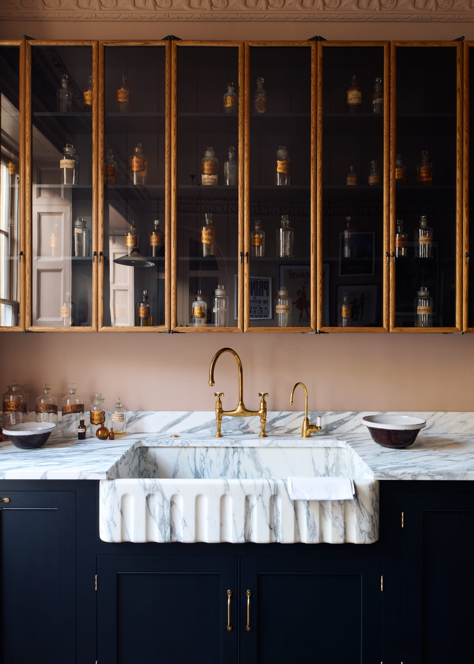 glass fronted wall cabinet above a kitchen sink