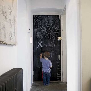 hallway with white wall and black door