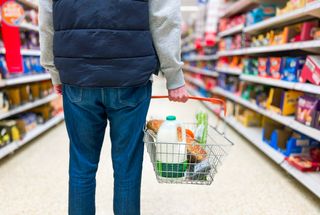 Man holding shopping basket in supermarket