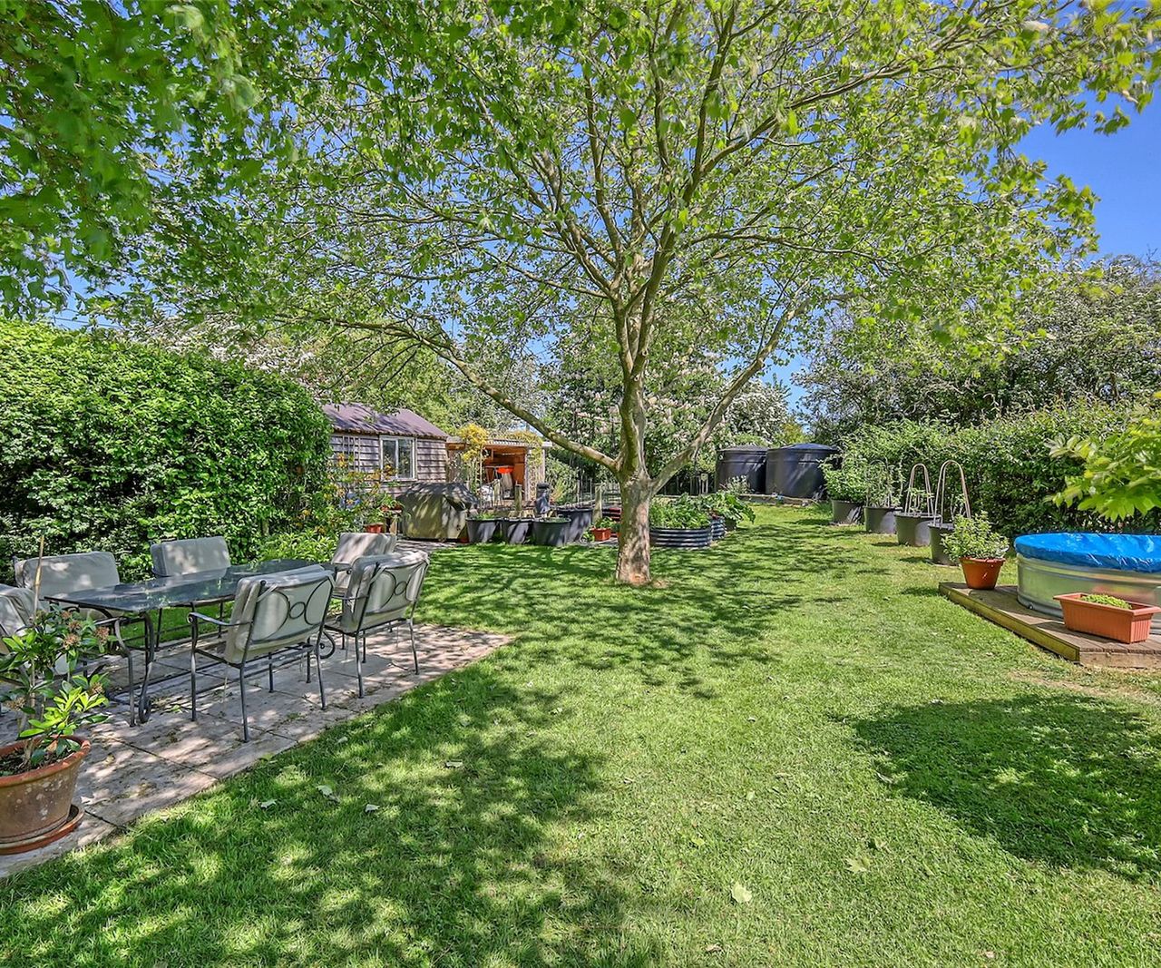 A garden with an above ground swimming and an outdoor seating area