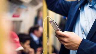 Young handsome businessman with smartphone in subway