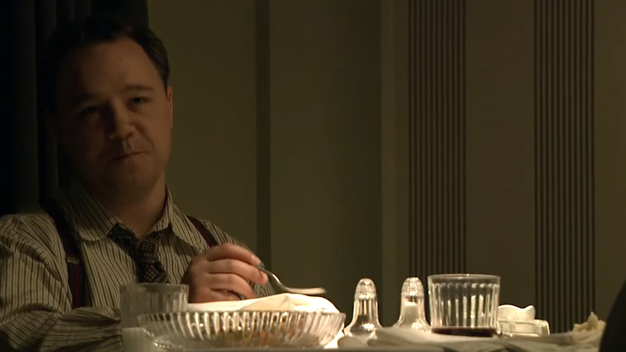 Stephen Graham smiling and eating at a table as Baby Face Nelson in Public Enemies