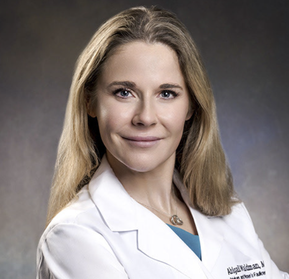 a white woman with blonde hair in a white lab coat