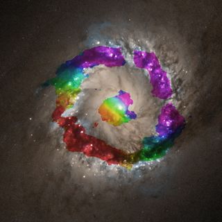 This photo overlays the velocity of the hydrogen cyanide gases over the galaxy NGC 1097. Red shows the gas moving away from us and blue shows it approaching us — and by tracking those movements the researchers were able to work out the central black hole's mass.