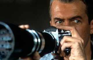 James Stewart looks through his camera in a scene from Hitchcock film